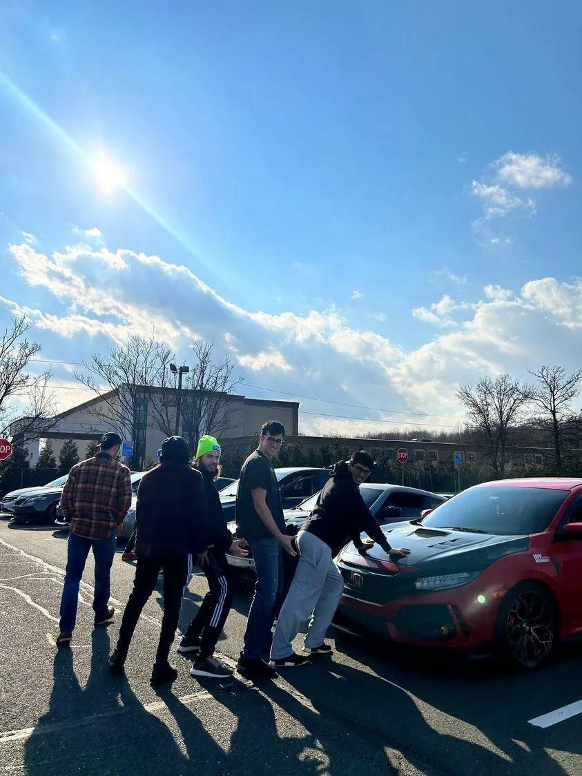 Club members gathered around a red Honda Civic Type R at a daytime meet
