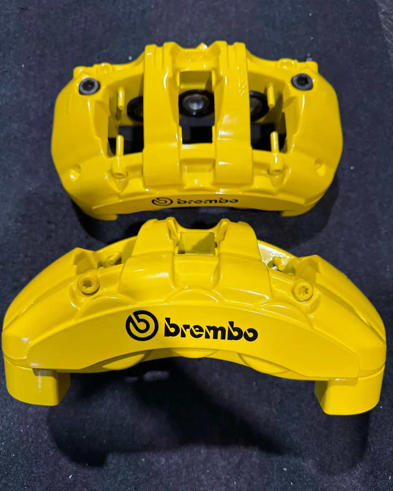 A pair of yellow Brembo calipers seen from above