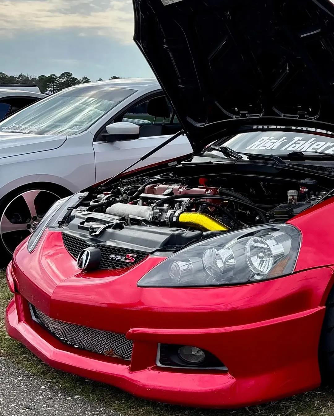 A red Acura RSX with the hood open